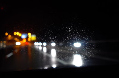 Close-up of wet car against sky at night