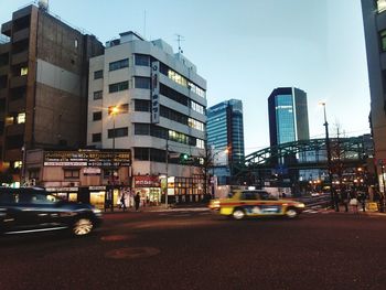 Cars on road in city against clear sky