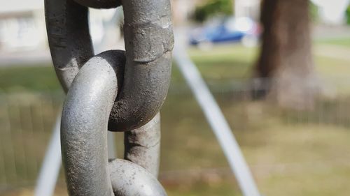 Close-up of chain swing hanging in park