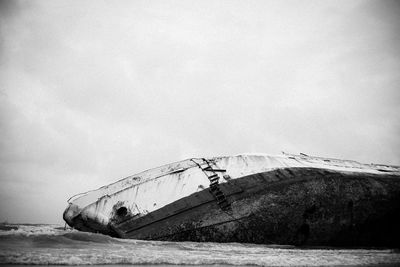 Shipwreck in sea against sky