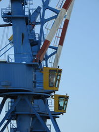 Low angle view of crane against clear blue sky