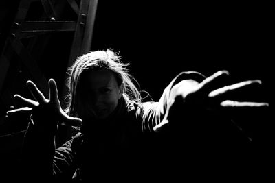 Woman gesturing in darkroom