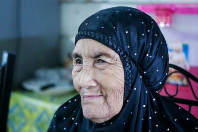 Close-up of senior woman wearing hijab at home