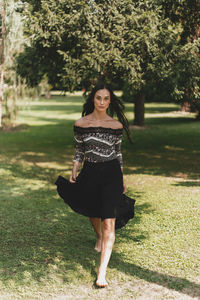 Portrait of young woman walking on grass