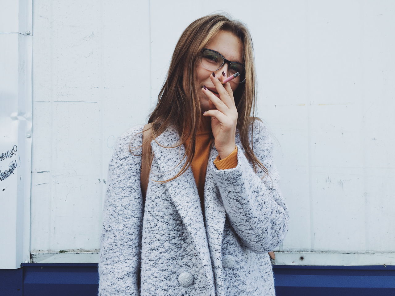 WOMAN STANDING AGAINST WALL