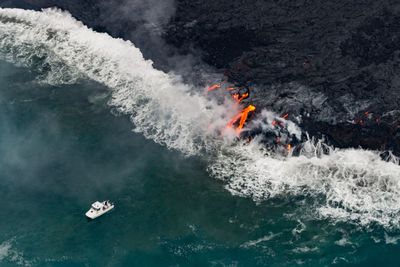 High angle view of active volcano by sea