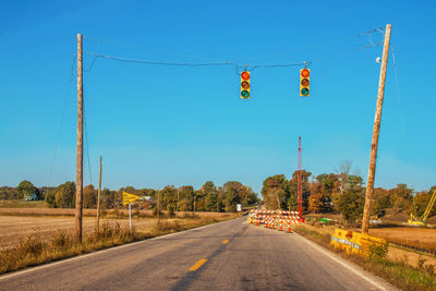 Low angle view of road against clear blue sky