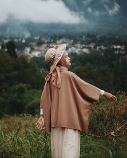 Midsection of person wearing mask standing on field