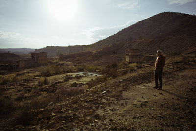 Rear view of woman standing on landscape against sky