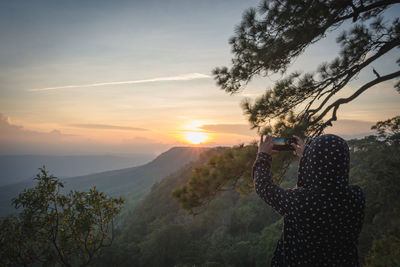 Man photographing at sunset