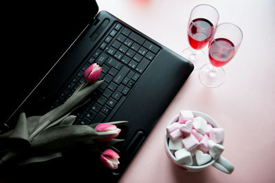 Red wine and marshmallow with laptop on table