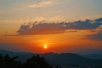 Scenic view of silhouette mountains against romantic sky at sunset