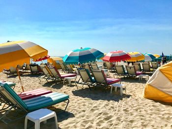 Lounge chairs on beach against sky