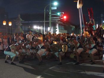 Crowd sitting on street at night