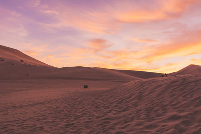 Scenic view of desert against cloudy sky