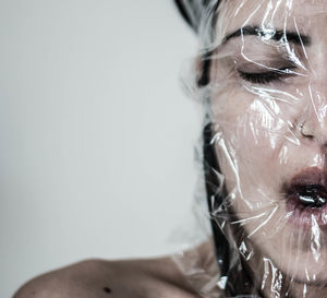 Close-up of young woman with plastic on face