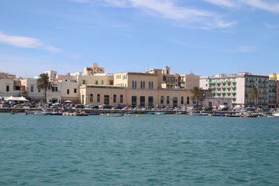 View of buildings by sea against sky