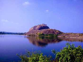 Scenic view of lake and mountains against blue sky