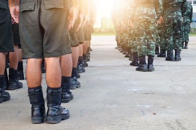 Low section of army soldiers standing on road 