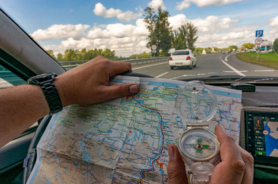 Cropped hand of man holding navigational compass