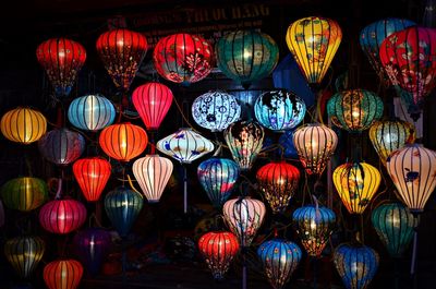 Illuminated lanterns hanging at night for sale at market