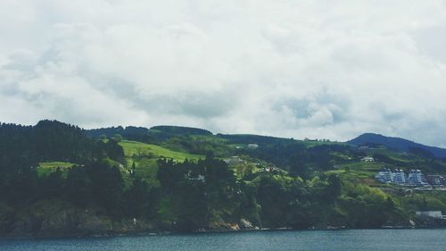 Scenic view of calm lake against cloudy sky