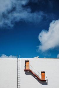 Low angle view of steps on wall against sky