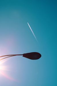 Low angle view of airplane flying against clear blue sky