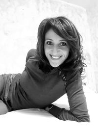 Portrait of smiling mid adult woman lying on bed at home