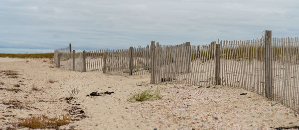 Wooden fence on field against sky