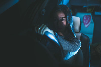 Portrait of woman driving car at night