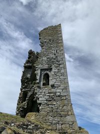 Low angle view of old building against cloudy sky
