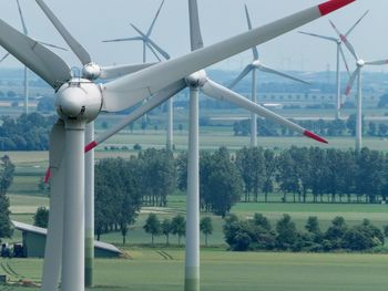 Built structure on field by trees against sky