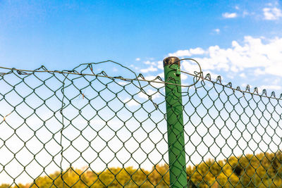 Low angle view of chainlink fence against sky