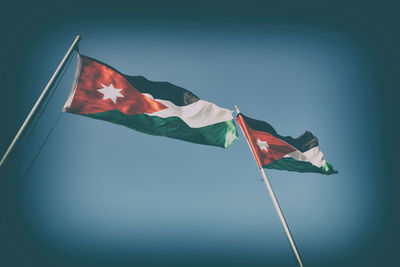 Low angle view of flags flag against sky