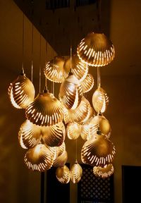 Low angle view of illuminated pendant light hanging on ceiling