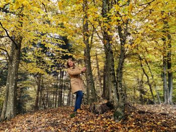 Woman standing in forest during autumn