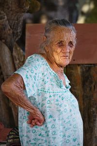 Close-up of senior woman in nightwear standing outdoors