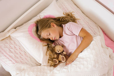 Sweet little kid girl having healthy day nap in bed