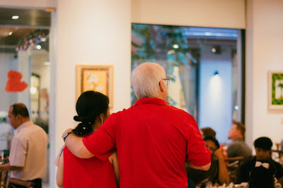 Rear view of people walking in corridor