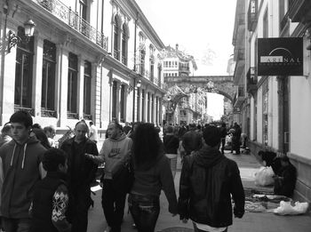 People walking on street amidst buildings in city