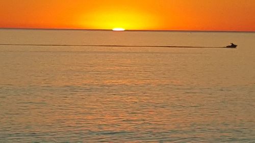 Scenic view of sea against orange sky