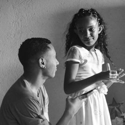 Portrait of mother and daughter against wall