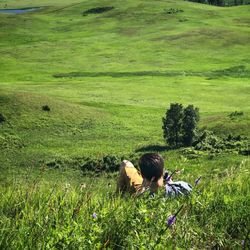 Rear view of teenage boy resting on grassy field