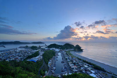 High angle view of city by sea against sky