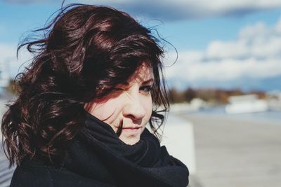 Portrait of woman winking against sky