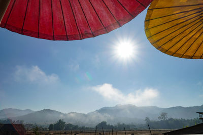 Low angle view of parasol against sky on sunny day