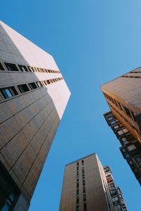 Low angle view of modern buildings against clear blue sky