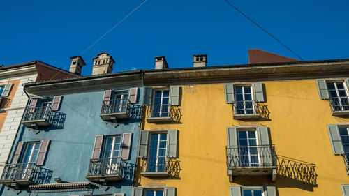 Low angle view of residential building against clear blue sky
