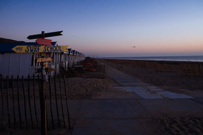 Scenic view of beach against clear sky during sunset